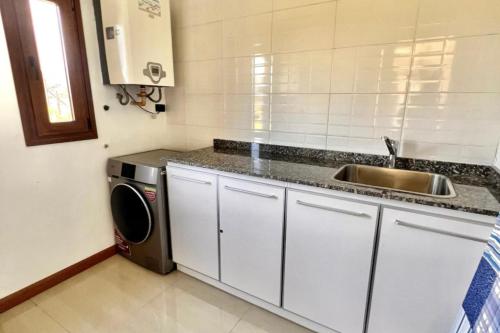 eine Küche mit Spüle und Waschmaschine in der Unterkunft LUXURY Casa cerca al centro en El Calafate Glacial, Argentina in El Calafate