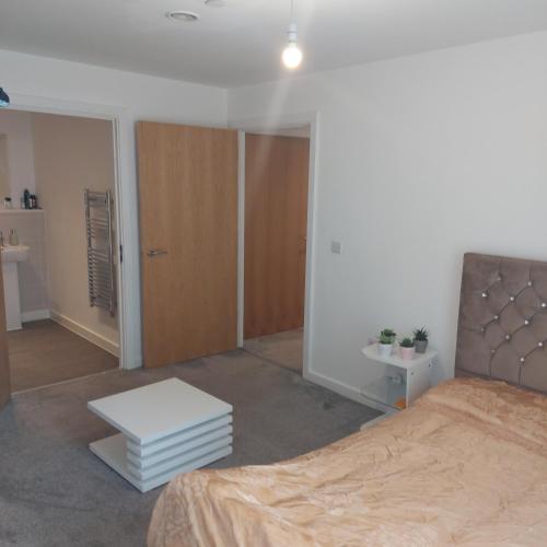 a bedroom with a bed and a table in it at Ensuite Double Bedroom, Live in landlord in Warrington