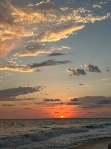 a sunset on the beach with the sun setting at Ocean Front- Marina View- Tiara Sands Resort, Sleeps 4 in Mazatlán