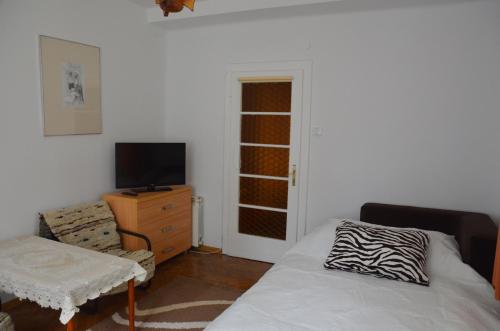 a bedroom with a bed and a tv and a dresser at Willa Wanda in Zakopane