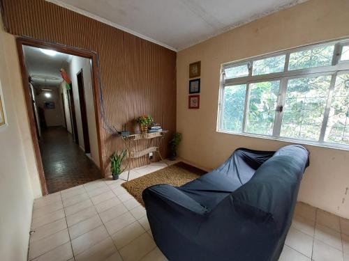 a living room with a blue couch and a window at Hostel Pantanal Em Florianópolis in Florianópolis