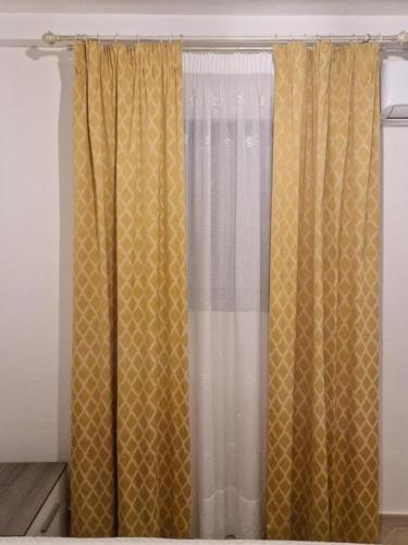 a bedroom with yellow curtains in a room at B&B Sud Salento in Alessano