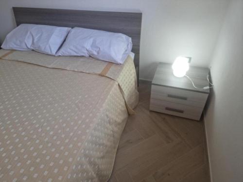 a bedroom with a bed and a night stand with a lamp at B&B Sud Salento in Alessano