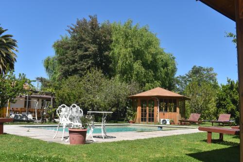 a swimming pool with a gazebo and a house at Hostal Pando in Santa Cruz