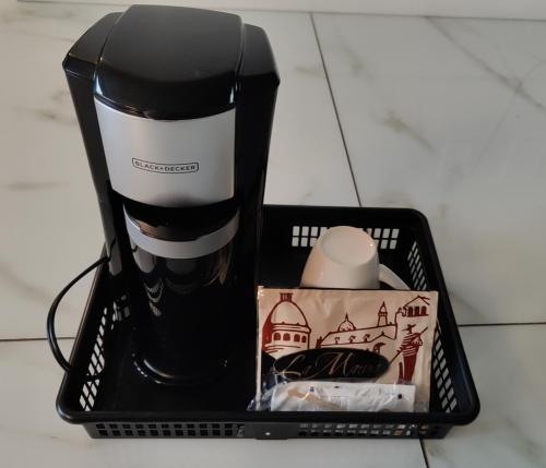 a black and white coffee maker in a basket at Queens Suite in West Vancouver
