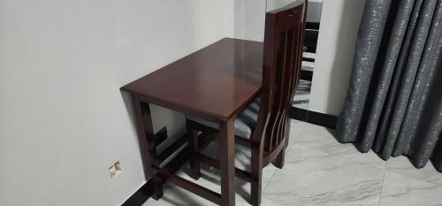 a wooden table sitting next to a wall at Aquifers Executive Bed and Breakfast in Lilongwe