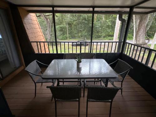 a table and chairs on a screened in porch at The Salty Sandcastle Townhome in Port Orange