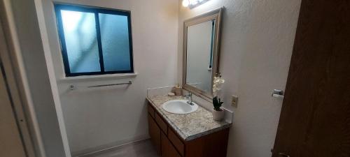 a bathroom with a sink and a mirror and a window at 4-plex Apartment in Burien - Unit 1 - 7 min from Sea Tac Airport - 15 min from Downtown Seattle in Burien
