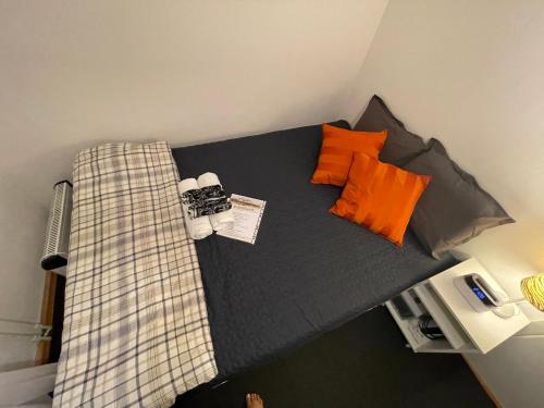 a bedroom with a bed with orange pillows at Independent Cozy apartment in husby in Stockholm