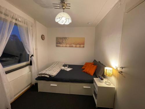 a small bedroom with a bed with a window at Independent Cozy apartment in husby in Stockholm