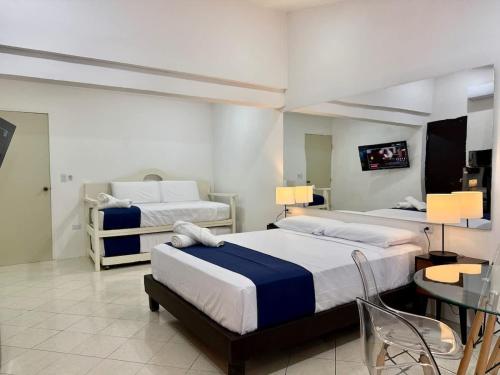 ein Schlafzimmer mit zwei Betten und einem Tisch und Stühlen in der Unterkunft Hermoso y brillante alojamiento con piscina in Mérida