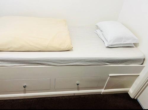 a bed with white sheets and pillows on it at Budget Stay In Luton 01 R in Luton