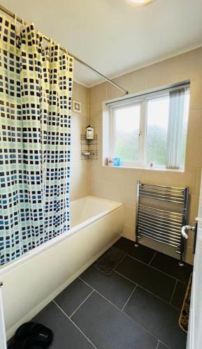 a bathroom with a tub and a window at Budget Stay In Luton 01 R in Luton