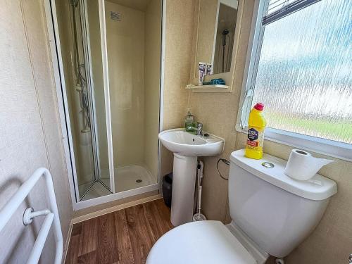 a bathroom with a toilet and a sink and a shower at Cosy Dog Friendly Caravan, Near To Great Yarmouth In Norfolk Ref 10029Rp in Belton