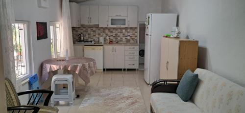 a kitchen with a couch and a table and a refrigerator at Günışığı Pansiyon & Apart in Koycegiz