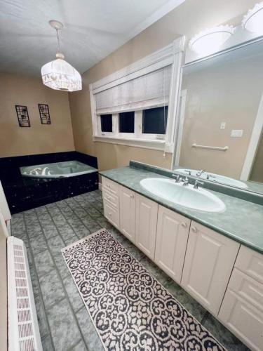 a bathroom with a sink and a tub at Chalet At The Beach in Seguin 