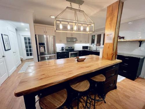a kitchen with a large wooden table with stools at Chalet At The Beach in Seguin 