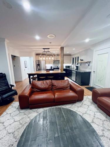 a living room with a leather couch and a table at Chalet At The Beach in Seguin 