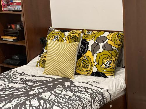 a bed with yellow and black pillows on it at Chalet At The Beach in Seguin 