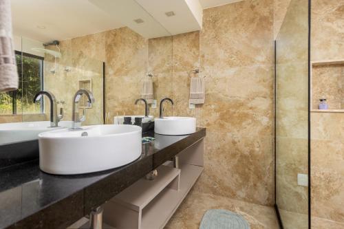 ブジオスにあるCasa da Bravaの洗面台2つとシャワー付きのバスルーム