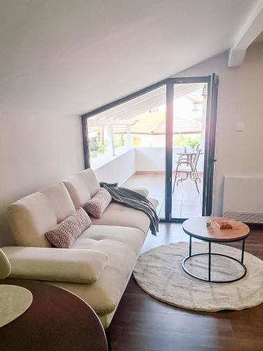 a living room with a white couch and a table at Harmonia Apartments in Bitola