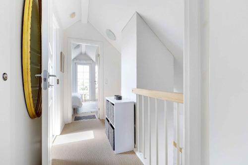 a hallway with white walls and a white stair case at Idyllic Holiday Home By Beach And Nature in Bro