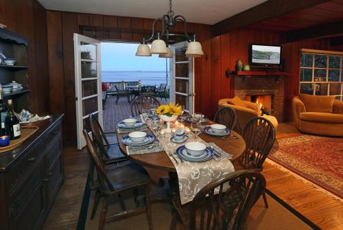 a dining room with a table with chairs and a fireplace at Rincon Retreat by Paradise Retreats in Carpinteria