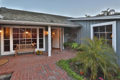 a house with a bench on a brick patio at Rincon Retreat by Paradise Retreats in Carpinteria
