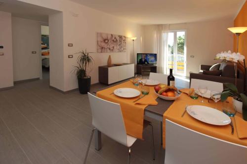 a dining room and living room with a table and chairs at Residence Rivachiara (check-in at Hotel Riviera in Viale Rovereto, 95) in Riva del Garda