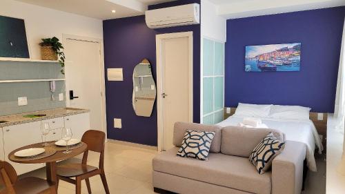 a bedroom with a bed and a couch and a table at Blend Coliving One - 2b in Ribeirão Preto