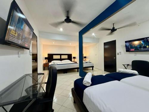 ein Hotelzimmer mit zwei Betten und einem Fernseher in der Unterkunft Sunlit Hideaway plus shared Pool for 6 in Mérida