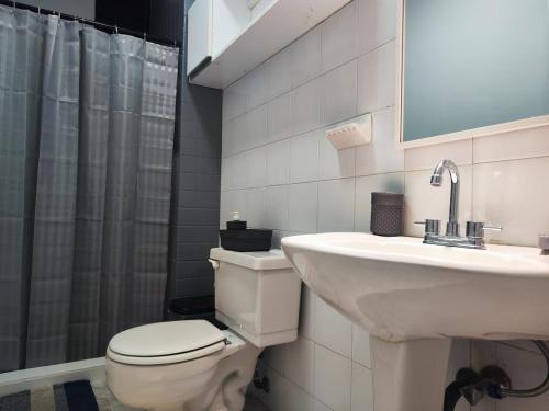 a bathroom with a toilet and a sink and a mirror at Tus vacaciones Ideales en Costa Azul Isla de Margarita in Porlamar