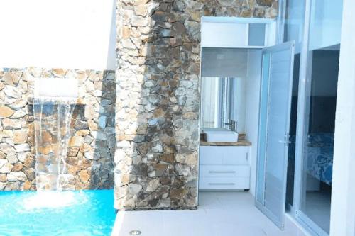 ein Badezimmer mit einem Waschbecken und einer Steinmauer in der Unterkunft NEW Bamboo Pacifica in Acapulco