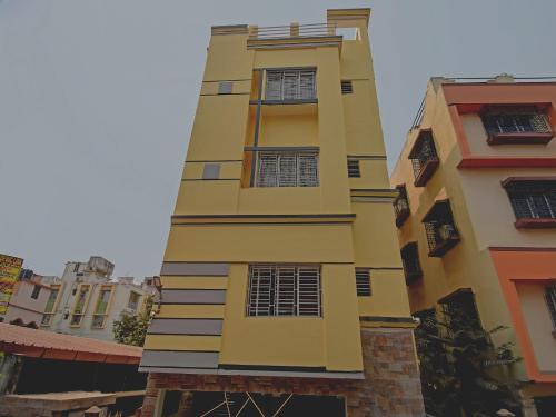 a tall yellow building with windows at Collection O Ketan Regency Near Acropolis Mall in Kolkata