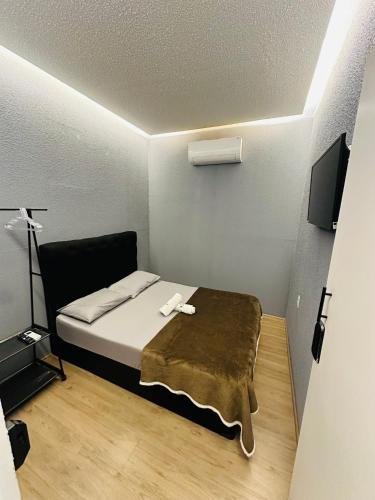 a small room with a bed and a flat screen tv at On Hotel Campos do Jordao centro capivari e Passeio Quadriciclo in Campos do Jordão