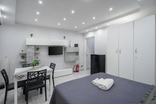 a room with a bed and a table and a kitchen at Smart’s House Deluxe Quartieri Spagnoli in Naples