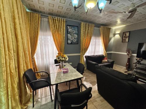 a living room with a table and a couch at Groove Vacation Homes in Kasoa
