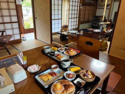 ein Tisch mit mehreren Tabletts mit Frühstücksspeisen darauf in der Unterkunft 一日限定一組の古民家の宿なんでもん in Naoshima