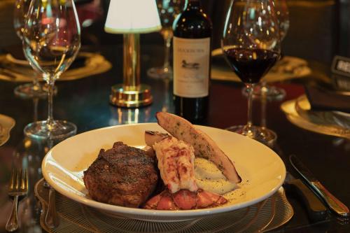 a plate of food on a table with wine glasses at Best Western Plus Columbia River Hotel in Trail