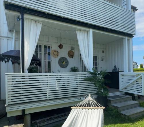 a porch of a white house with white curtains at Tønsberg centrum in Tønsberg