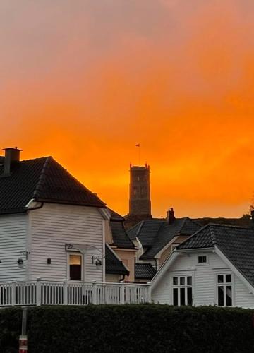 a white house with a clock tower in the background at Tønsberg centrum in Tønsberg