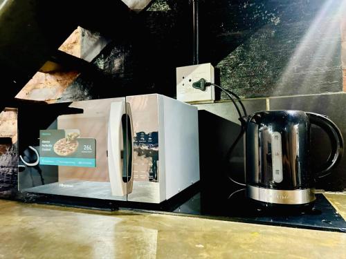 a microwave oven sitting on a counter with a tea kettle at Cozy Luxury apt in Maboneng in Johannesburg