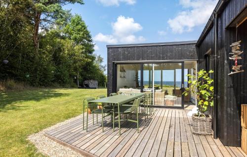 a wooden deck with a green table on a house at 4 Bedroom Cozy Home In Fur in Fur