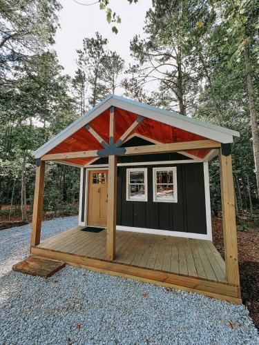a smallshed with a roof on top of gravel at Cabin #4 Studio With Kitchenette in Hartwell