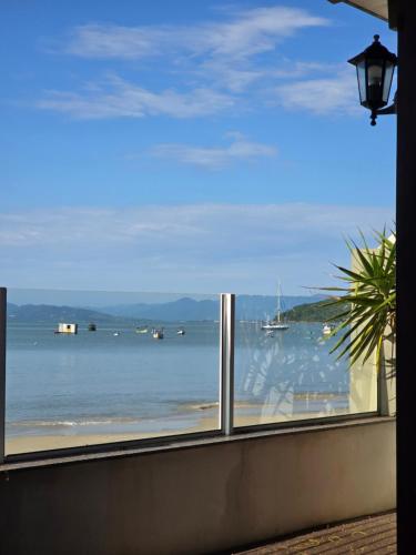 a view of the ocean from a window at Vila Alegria in Bombinhas
