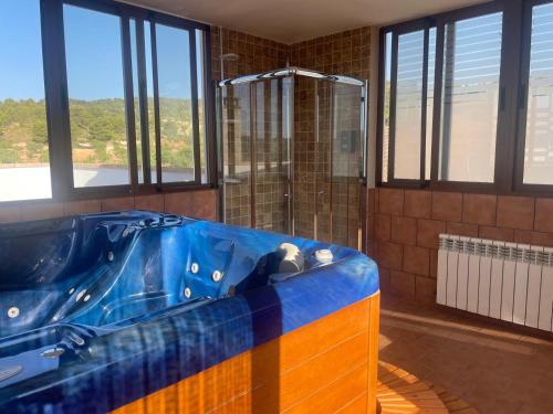 a large blue tub in a bathroom with windows at Posada Peñarubia in Peñarrubia