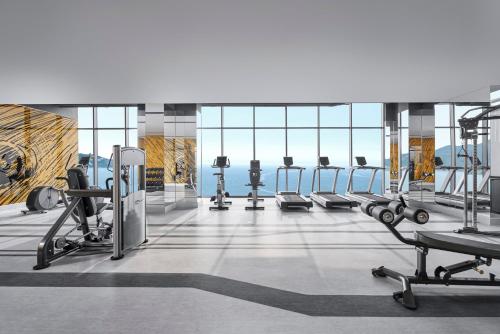 a gym with several treadmills and machines at voco Ma Belle Danang by IHG in Da Nang