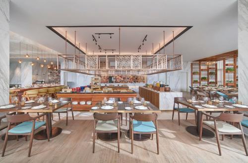 a rendering of a restaurant with tables and chairs at voco Ma Belle Danang by IHG in Da Nang