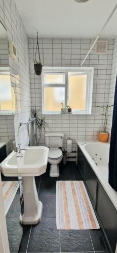 a bathroom with a sink and a toilet and a tub at Double Bed at Cozy Hailsham in London