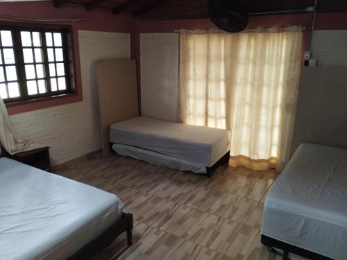 a room with two beds and a window at Hostel Recanto Encanto in Jaguariúna